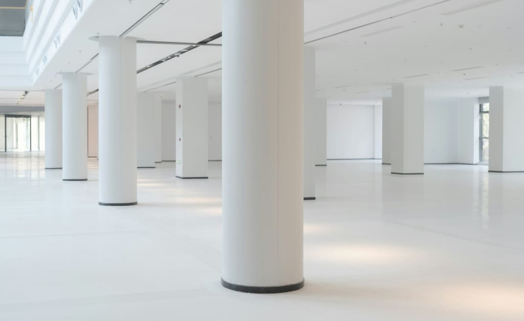 A spacious commercial interior with clean floors and simple, uncluttered surfaces.